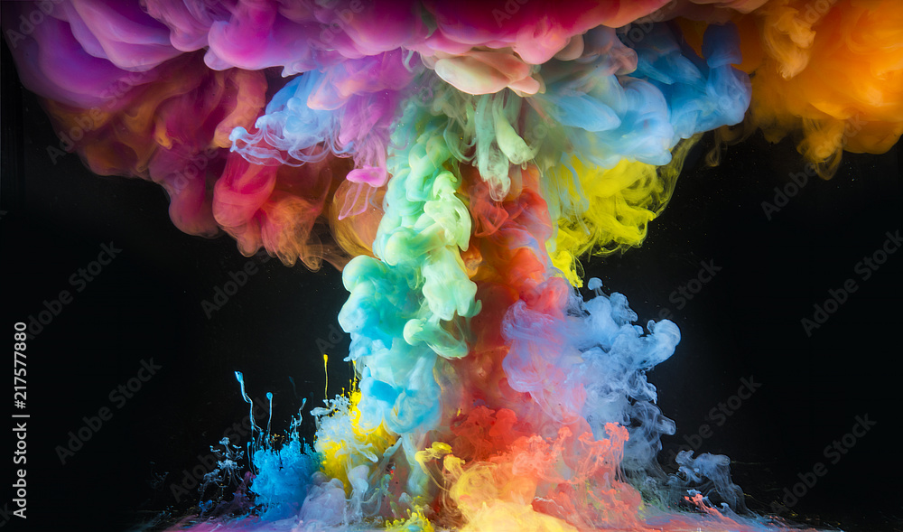 Colorful rainbow paint drops from above mixing in water. Ink swirling underwater. Colorful rainbow paint drops from above mixing in water. Ink swirling underwater.