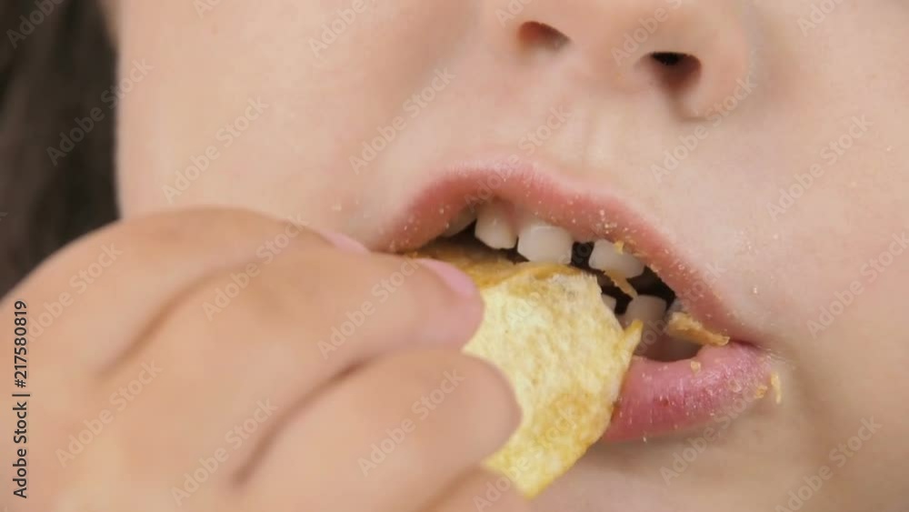 A child eats fast food. Close-up of a child eating chips. A child eats fast food. Close-up of a child eating chips.