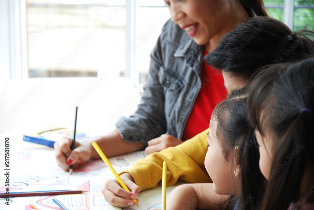 Teachers are teaching drawing on white paper to three children in holiday weekend. Background blur Teachers are teaching drawing on white paper to three children in holiday weekend. Background blur