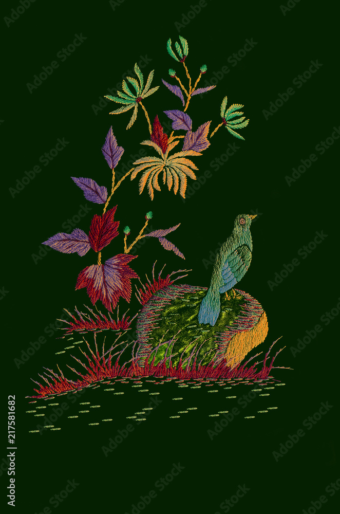 Bird on a stone near a branch with yellow-blue chrysanthemums and motley autumn leaves on dark green background

