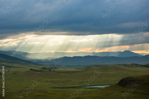 Sunset over the mountain landscape. A beautiful sun rays with clouds. Republic Of Khakassia  Russia.