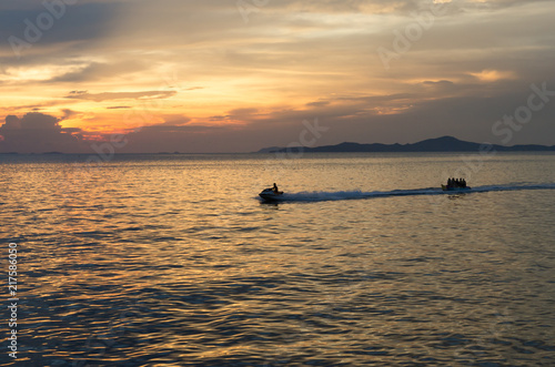 speed boat and banana boat into the sea with sunset © Khwanchai