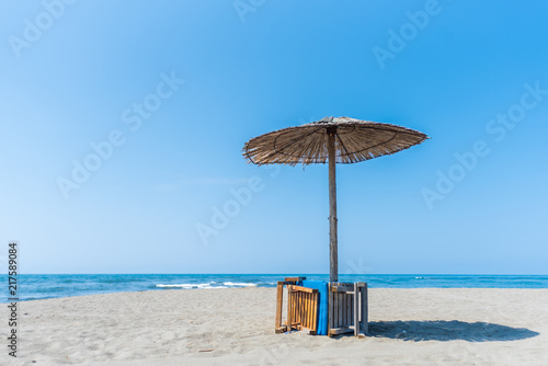 Fototapeta Naklejka Na Ścianę i Meble -  Panorama with sandy beach with wooden umbrellas and deck chairs