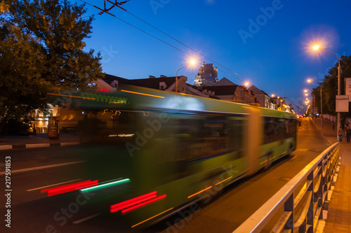The motion of a blurred bus in the street in the evening.