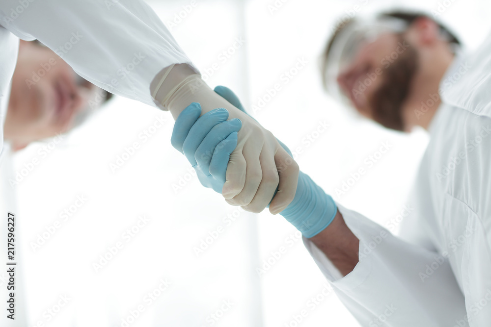 closeup.two scientists shake hands. closeup.two scientists shake hands.