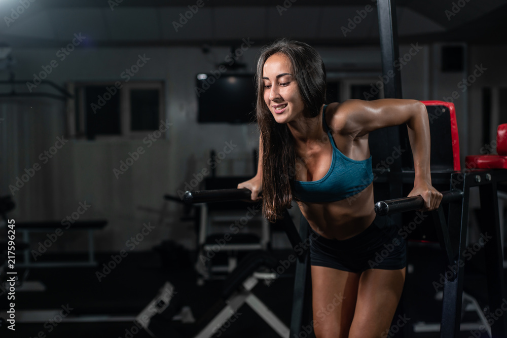 Fitness woman doing push-ups on uneven bars in crossfit gym. Fitness woman doing push-ups on uneven bars in crossfit gym.