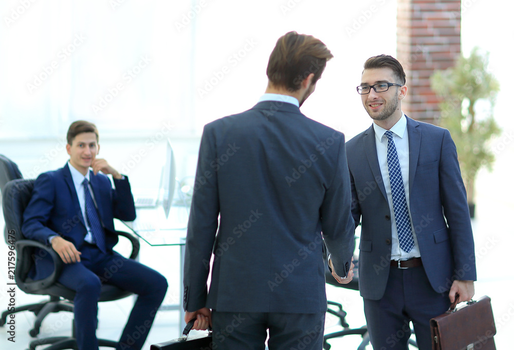 Two businessmen handshaking after striking grand deal Two businessmen handshaking after striking grand deal