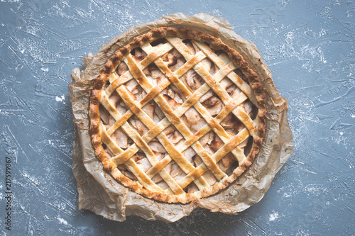 Traditional homemade delicious apple pie on the blue rustic table. Top view