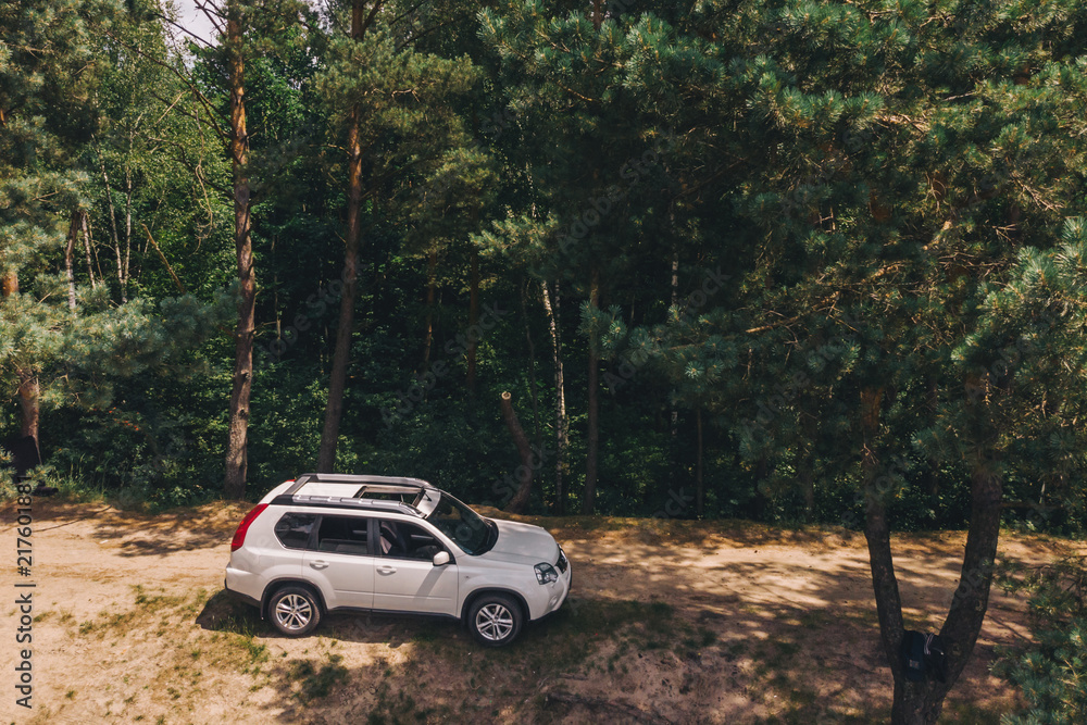 white suv in forest. aerial view. car travel concept