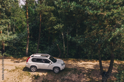 white suv in forest. aerial view. car travel concept