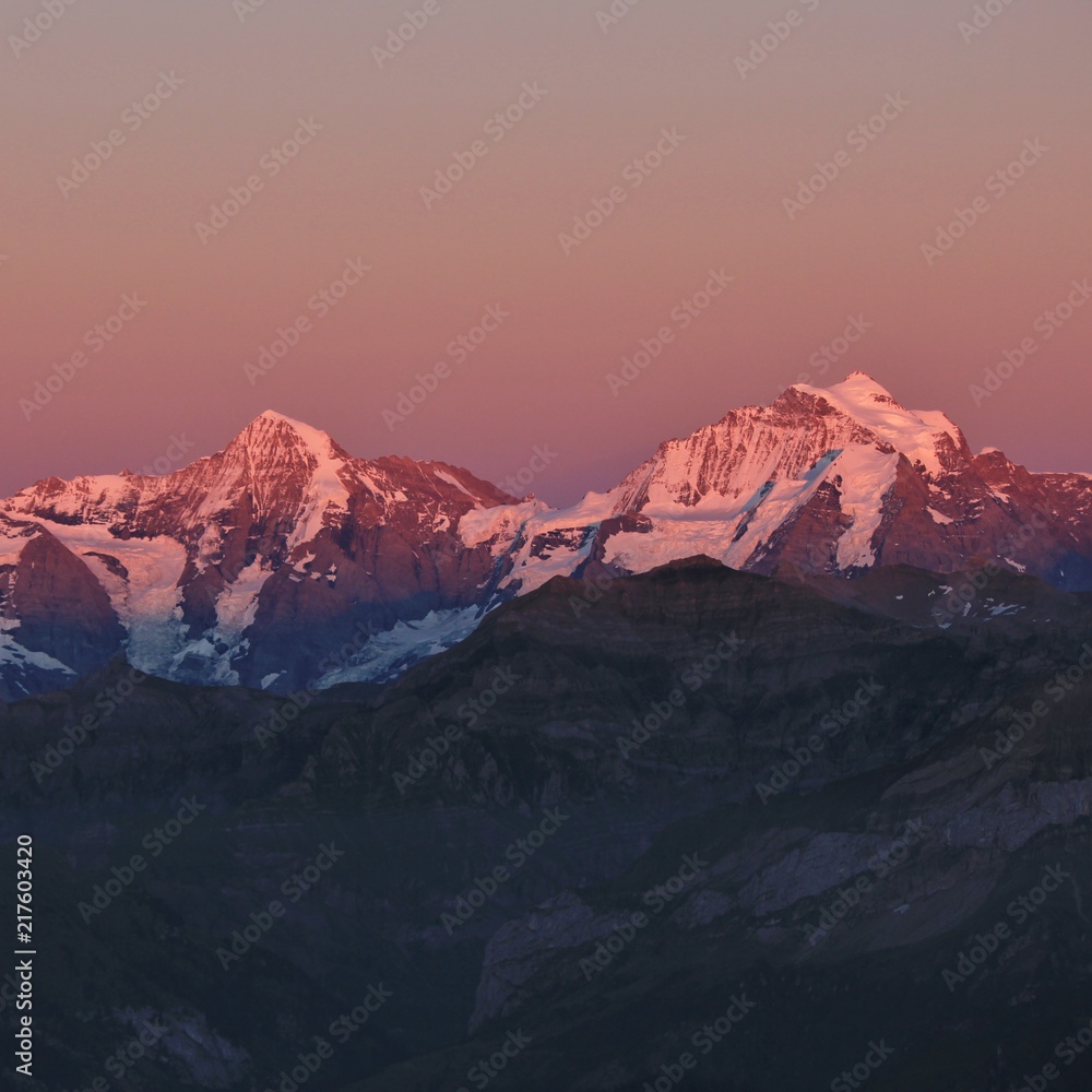Famous mountains Monch and Jungfrau at sunset. View from Mount Niesen. Bernese Oberland, Switzerland.