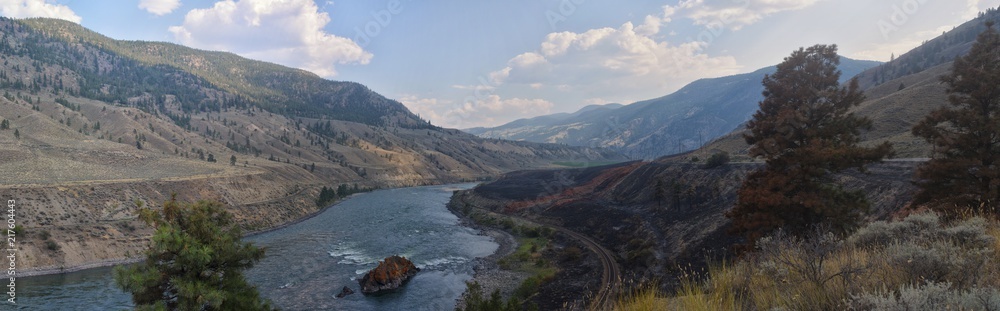 Fototapeta premium Panorama of the Thompson River with wildfire scarring on one side. Located north of Spence Bridge