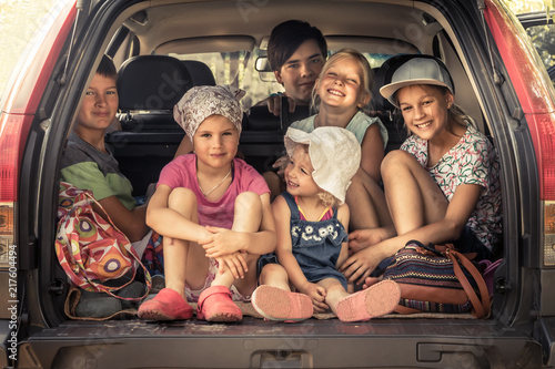 Group of children in family car trunk luggage going to road trip in family car symbolizing kids togetherness friendship and happy carefree childhood