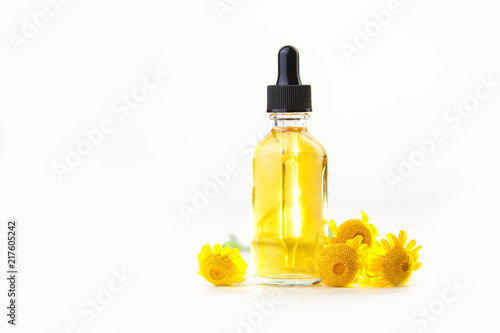 Essence of Yellow Camomille flowers on table in beautiful glass Bottle