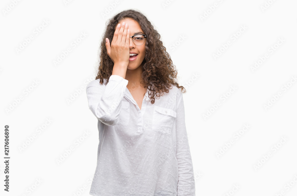 Beautiful young hispanic woman covering one eye with hand with confident smile on face and surprise emotion. Beautiful young hispanic woman covering one eye with hand with confident smile on face and surprise emotion.