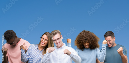 Composition of group of friends over blue blackground very happy and excited doing winner gesture with arms raised, smiling and screaming for success. Celebration concept.