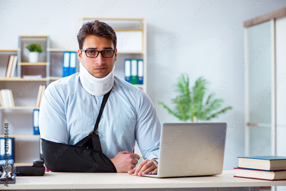 Businessman with broken arm working in office Businessman with broken arm working in office