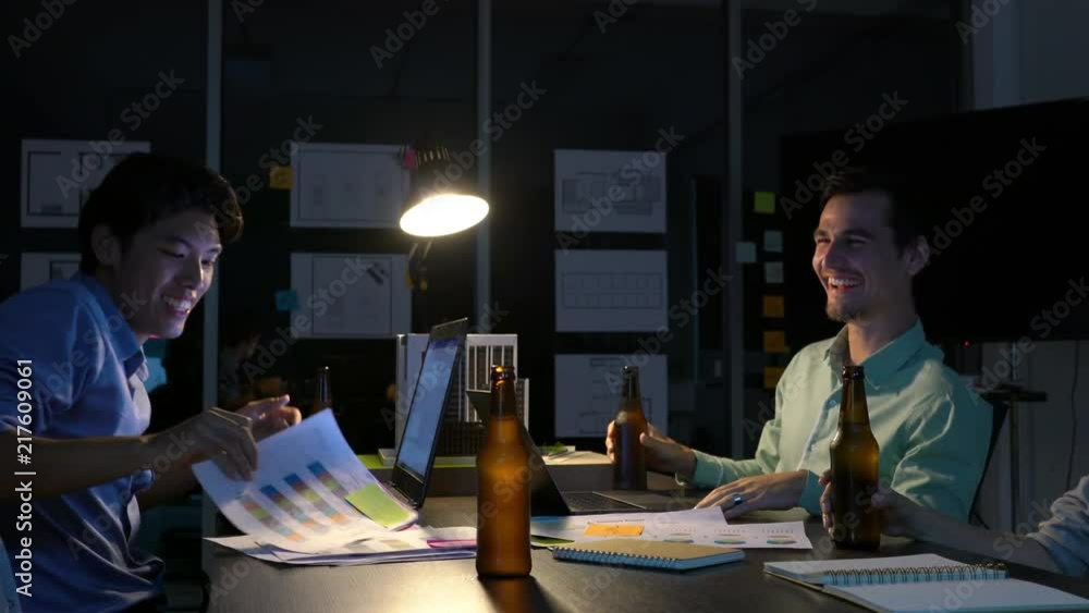 Team employee drinking happy for success project after hard working to late night at office. Business people work overtime. Concept of meeting room, business relax and reward. Team employee drinking happy for success project after hard working to late night at office. Business people work overtime. Concept of meeting room, business relax and reward.