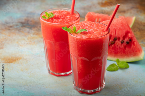 Watermelon slushie with lime, summer refreshing drink in tall glasses on a blue rusty background. with copy space photo