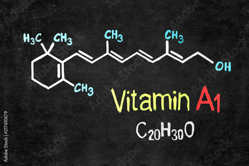 Handwritten chalk chemical formula of Vitamin A on school blackboard.