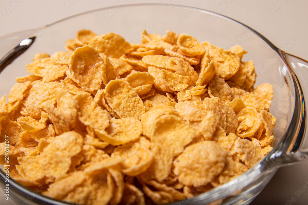 corn flakes in a glass plate on a gray background. corn flakes in a glass plate on a gray background.