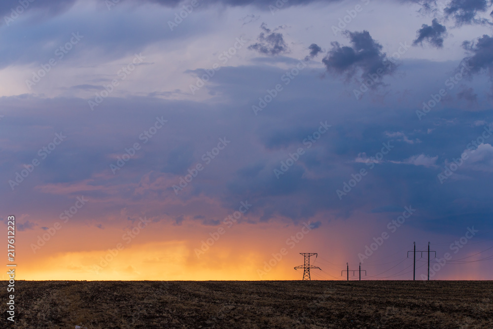 Rural landscape with high-voltage line on sunset