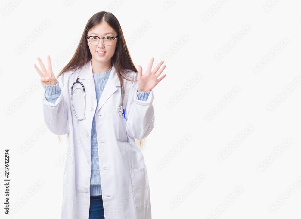 Young Chinese doctor woman over isolated background showing and pointing up with fingers number eight while smiling confident and happy. Young Chinese doctor woman over isolated background showing and pointing up with fingers number eight while smiling confident and happy.