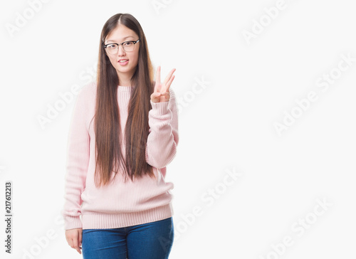 Young Chinese woman over isolated background wearing glasses showing and pointing up with fingers number three while smiling confident and happy.