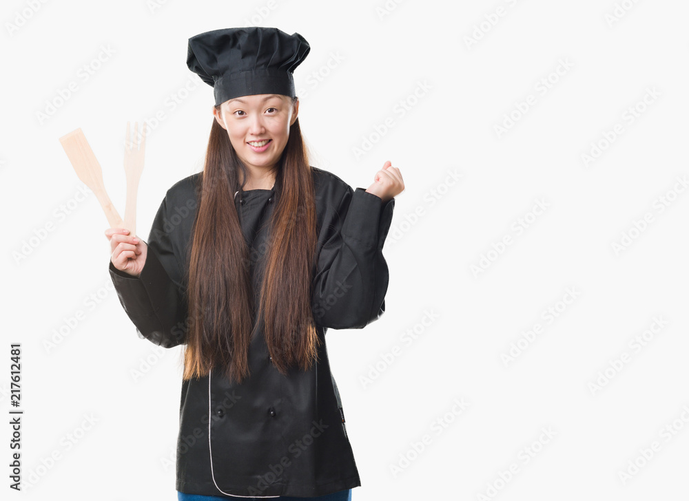 Young Chinese woman over isolated background wearing chef uniform screaming proud and celebrating victory and success very excited, cheering emotion Young Chinese woman over isolated background wearing chef uniform screaming proud and celebrating victory and success very excited, cheering emotion
