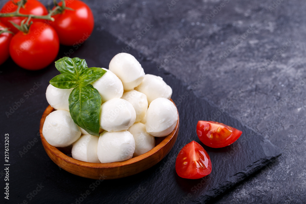 Mozzarella cheese, basil tomato cherry balsamic black slate stone copy space. Ingredients for Caprese salad Mozzarella cheese, basil tomato cherry balsamic black slate stone copy space. Ingredients for Caprese salad