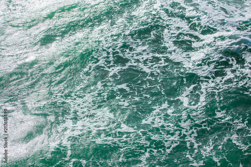 Fototapeta premium surface of turquoise ocean water with white foam, background, texture