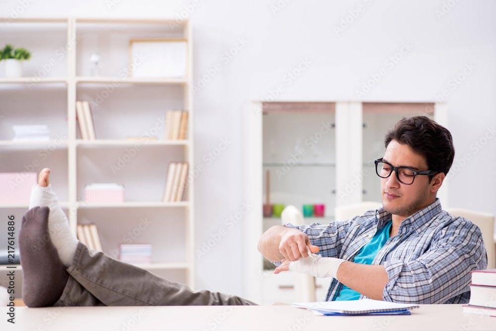 Young student man with hand injury preparing for the exams Young student man with hand injury preparing for the exams