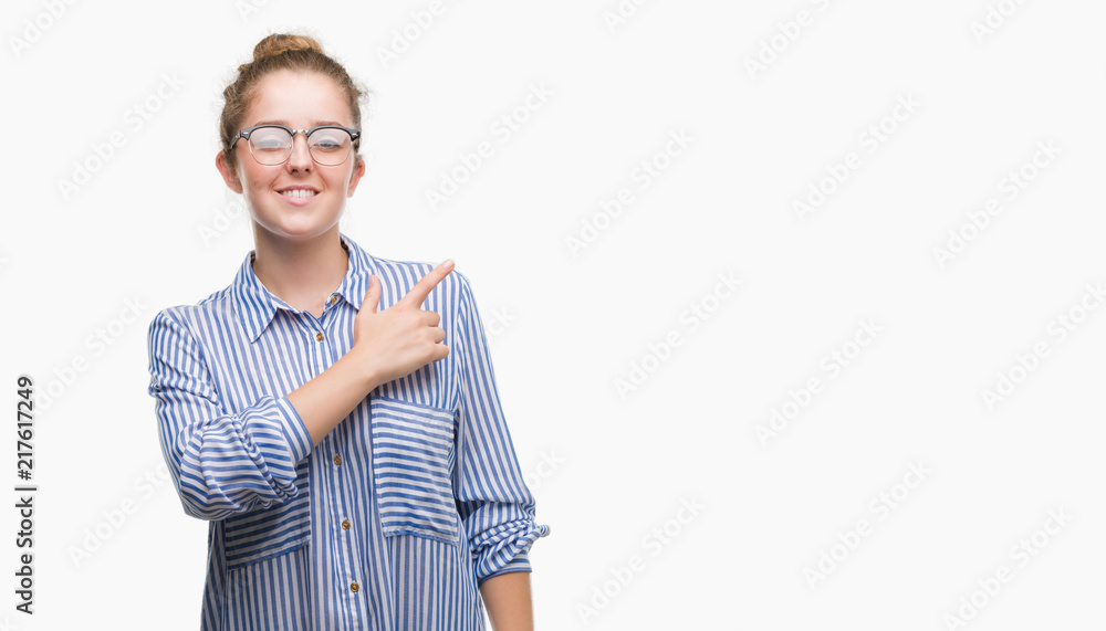 Young blonde business woman cheerful with a smile of face pointing with hand and finger up to the side with happy and natural expression on face looking at the camera. Young blonde business woman cheerful with a smile of face pointing with hand and finger up to the side with happy and natural expression on face looking at the camera.