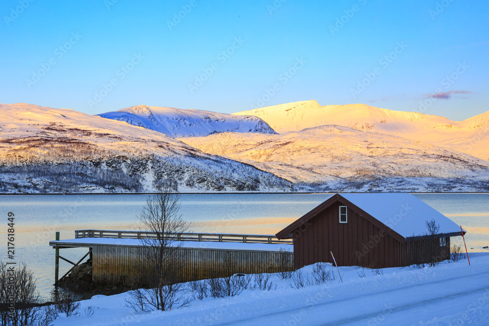 View on a house and snowy mountain peaks during sunset
