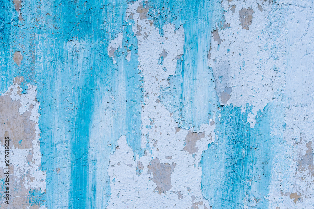 Blue painted wall textured looks unique as the paint is fading away and the cracks appear in a