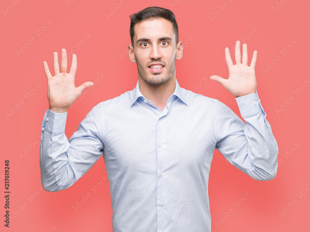 Handsome young businessman showing and pointing up with fingers number ten while smiling confident and happy. Handsome young businessman showing and pointing up with fingers number ten while smiling confident and happy.