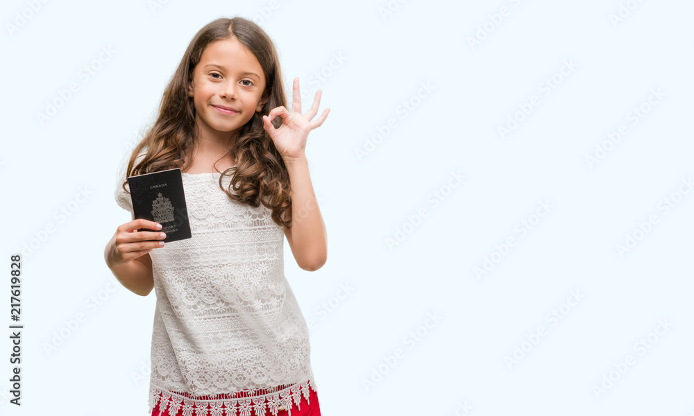 Brunette hispanic girl holding passport of Canada doing ok sign with fingers, excellent symbol Brunette hispanic girl holding passport of Canada doing ok sign with fingers, excellent symbol