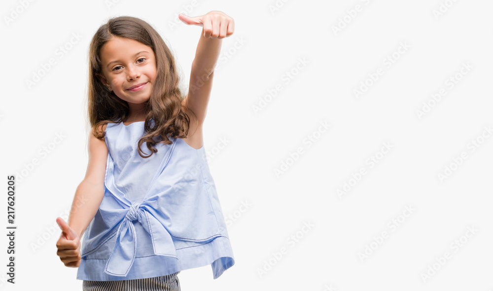 Brunette hispanic girl approving doing positive gesture with hand, thumbs up smiling and happy for success. Looking at the camera, winner gesture. Brunette hispanic girl approving doing positive gesture with hand, thumbs up smiling and happy for success. Looking at the camera, winner gesture.