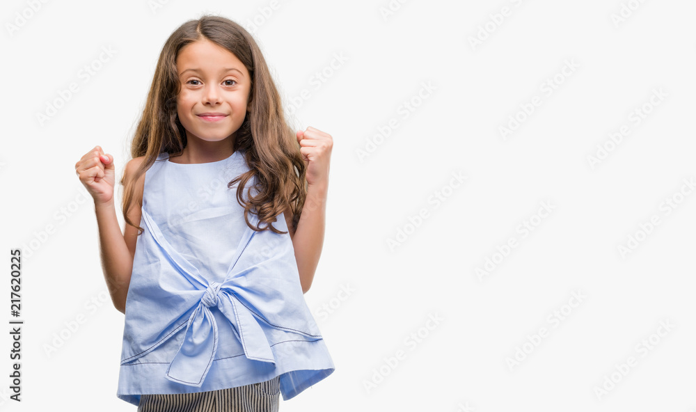 Brunette hispanic girl celebrating surprised and amazed for success with arms raised and open eyes. Winner concept. Brunette hispanic girl celebrating surprised and amazed for success with arms raised and open eyes. Winner concept.