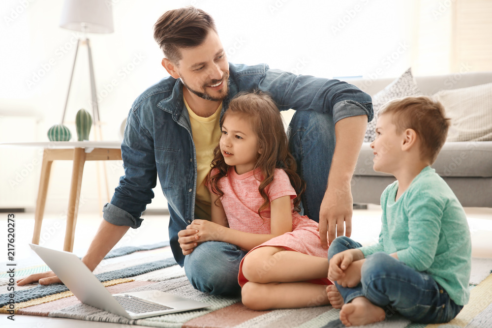 Young man using laptop with children at home. Happy family Young man using laptop with children at home. Happy family