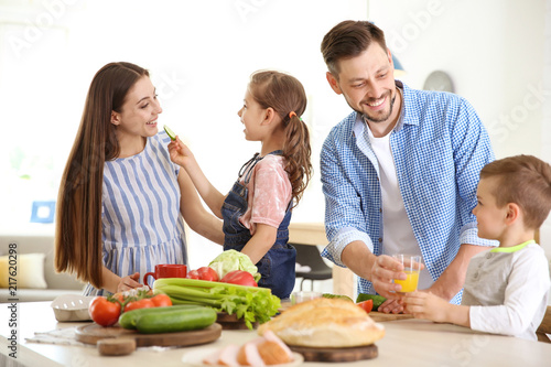 Happy family with children having breakfast in kitchen