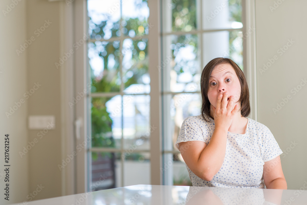 Down syndrome woman at home cover mouth with hand shocked with shame for mistake, expression of fear, scared in silence, secret concept Down syndrome woman at home cover mouth with hand shocked with shame for mistake, expression of fear, scared in silence, secret concept
