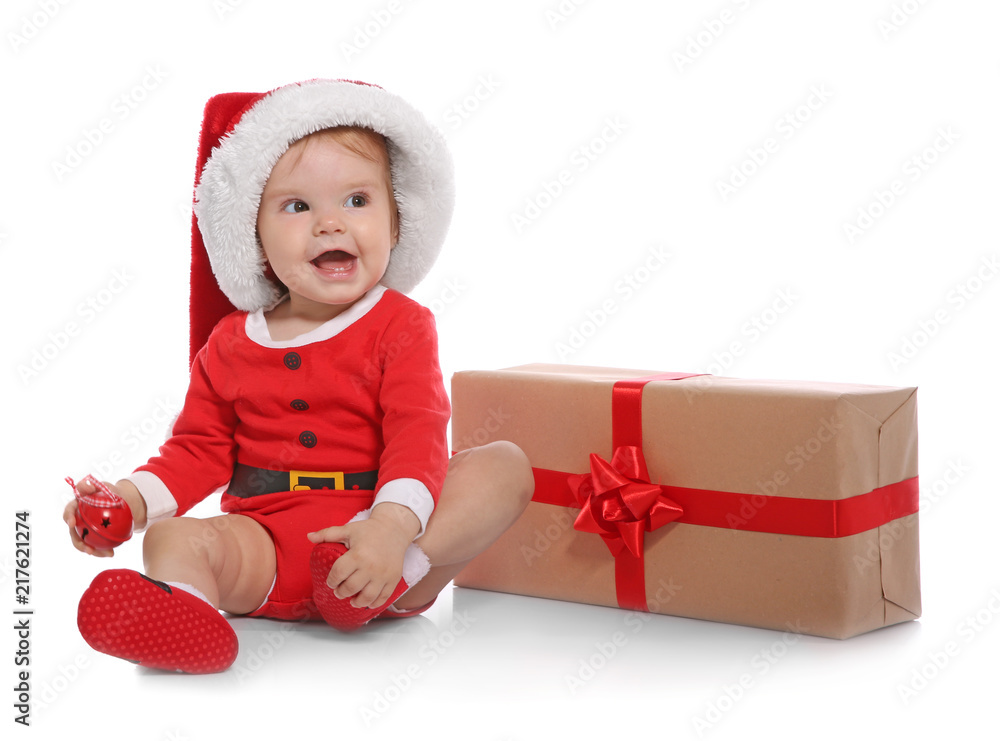 Cute little baby in Christmas costume and gift on white background Cute little baby in Christmas costume and gift on white background