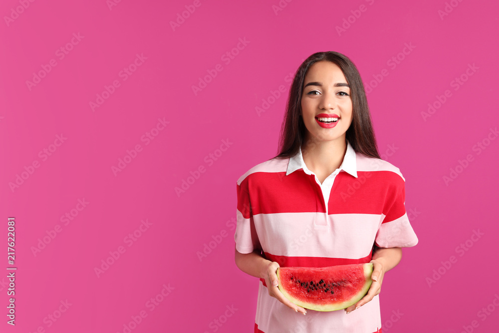 Beautiful young woman posing with watermelon on color background