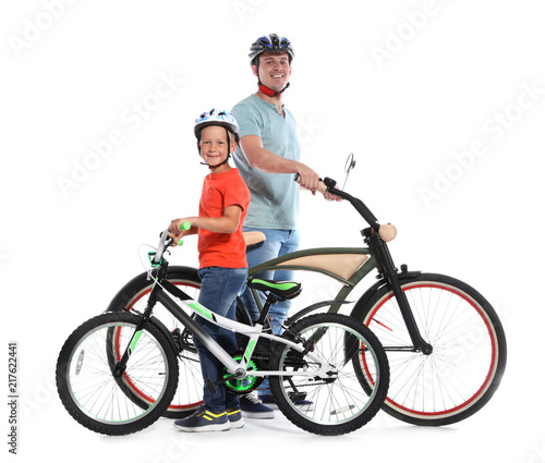 Portrait of father and his son with bicycles on white background