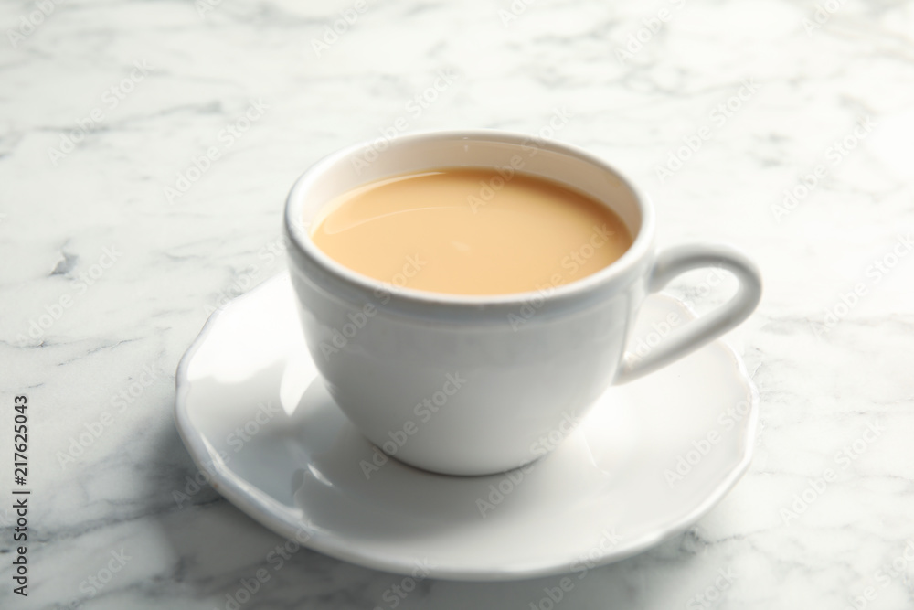 Cup with black tea and milk on marble table Cup with black tea and milk on marble table