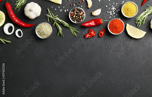 Flat lay composition with different aromatic spices and space for text on dark background
