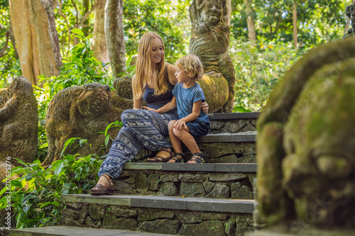 Mom and son travelers discovering Ubud forest in Monkey forest, Bali Indonesia. Traveling with children concept photo