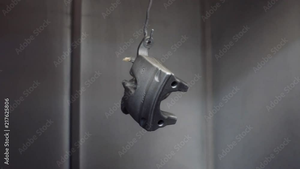 The painter paints the details of the car's brake system The painter paints the details of the car's brake system