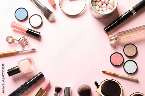 Flat lay composition with products for decorative makeup on pastel pink background